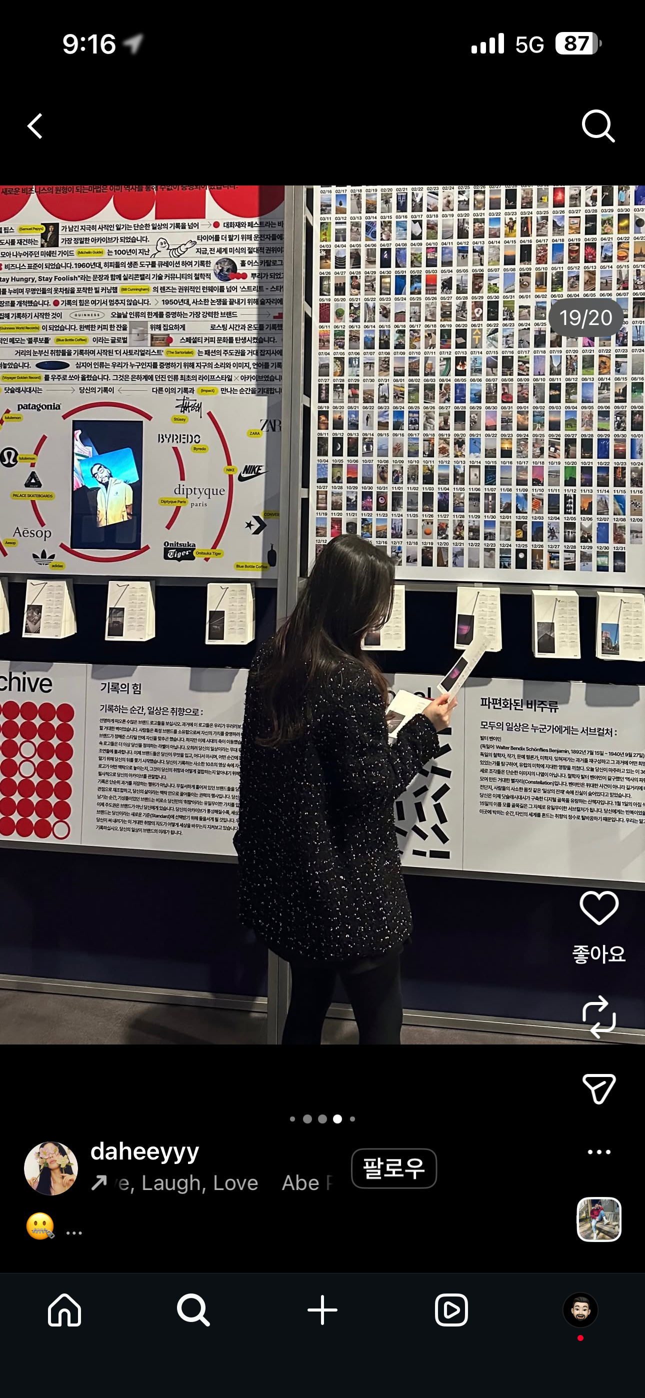 Social screenshot of a visitor reading a photographic calendar sheet in front of the display.